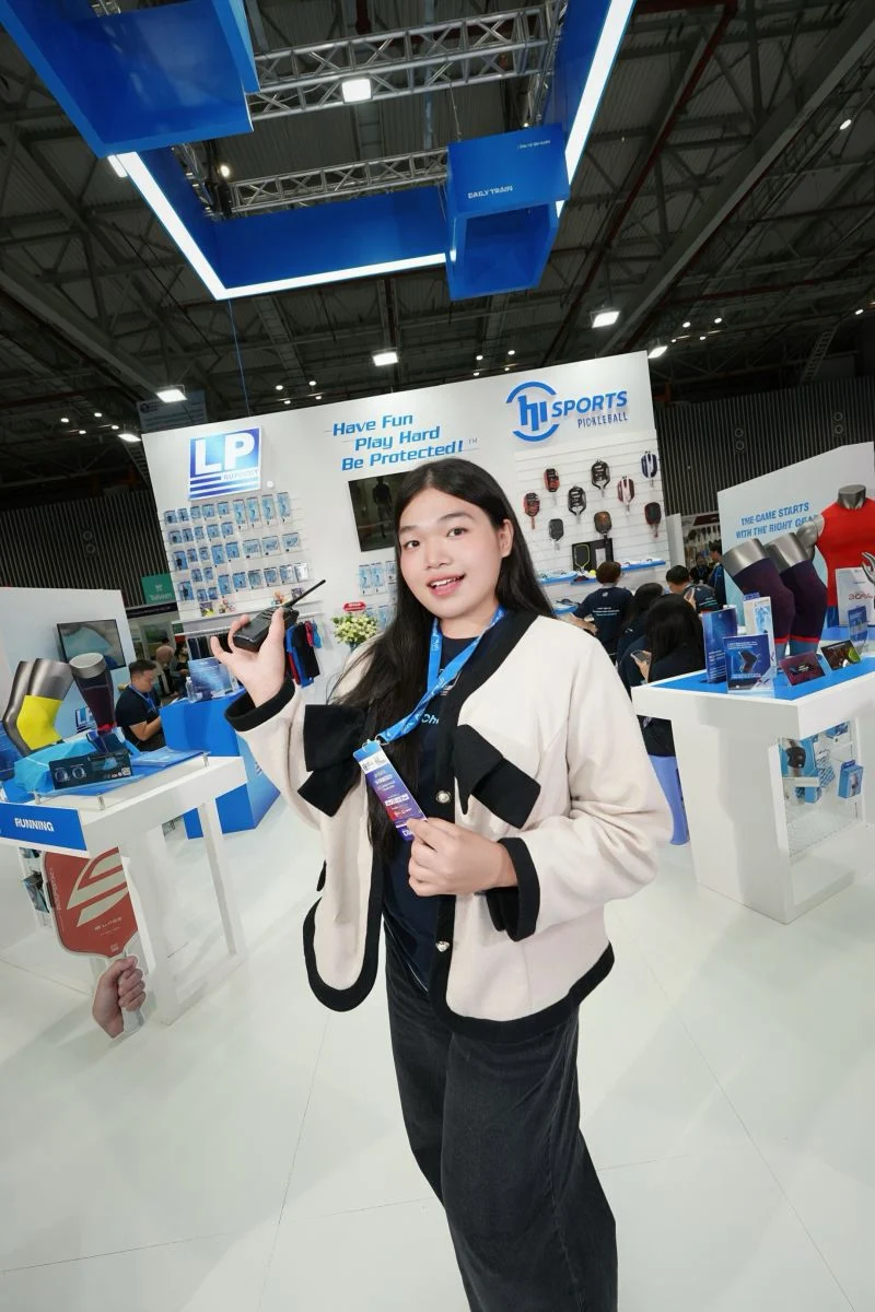 Jennie cầm bộ đàm tại gian hàng HISPORTS và LP Support.